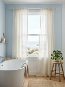 Sheer linen bathroom curtains filtering soft natural light into an airy coastal bathroom.