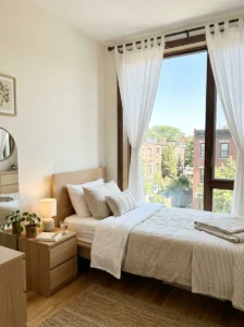Small bedroom with the bed positioned to keep the window and natural light unobstructed.