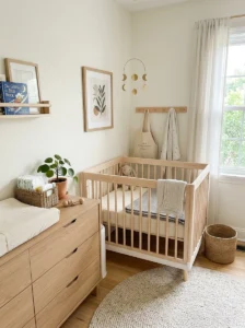 Compact nursery with a space-saving mini crib and neutral baby decor.