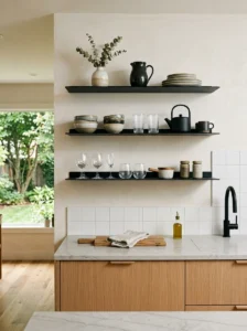 Open wood kitchen shelves displaying dishes and everyday items.