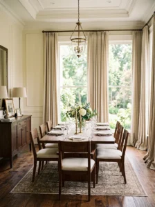 Floor-to-ceiling linen curtains in an elegant dining room.