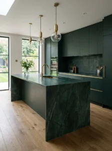 Luxury dark green kitchen with a dramatic waterfall-edge island.