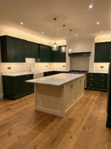 Dark green kitchen with a contrasting warm cream island.